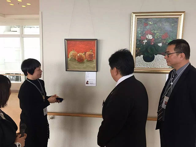 廣州青年美術(shù)家協(xié)會副主席楊健女士，為到場嘉賓、政府官員導(dǎo)賞參展佳作.jpg